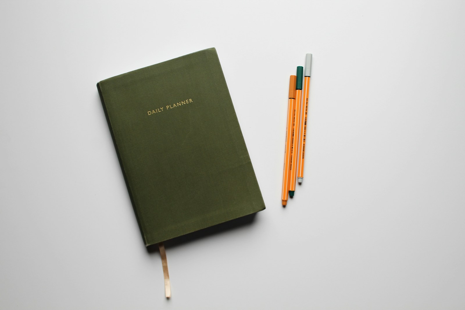 green book with pencils on white table